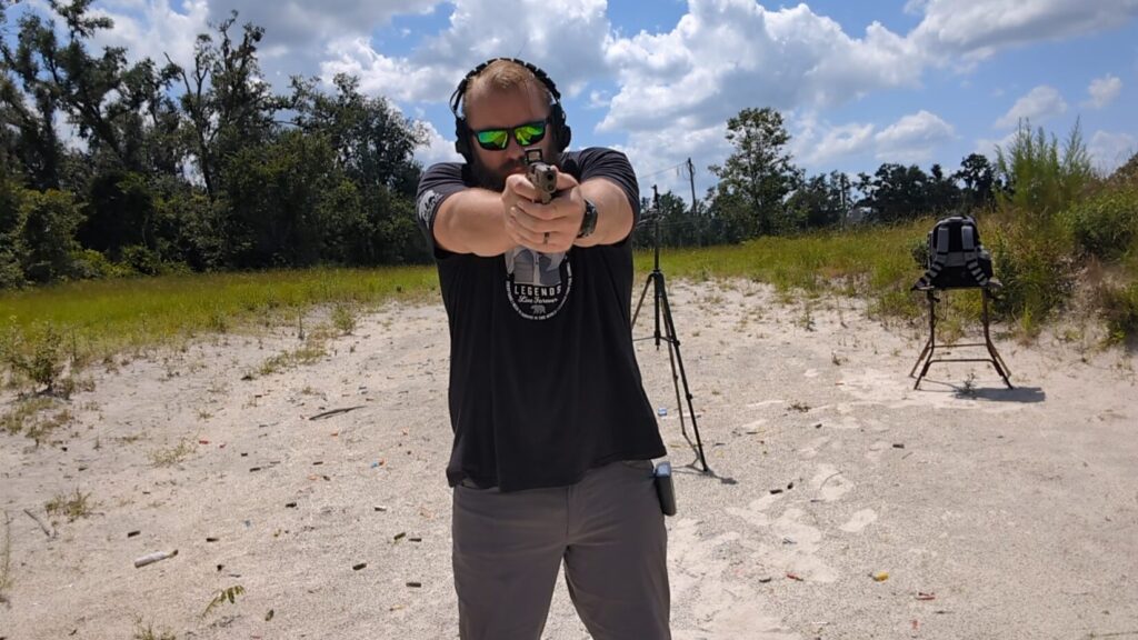 Man facing camera, aiming Sig Sauer P365 pistol