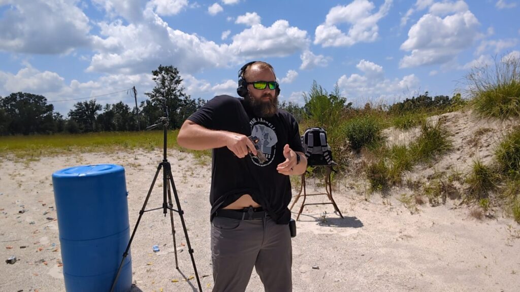 Man drawing Sig Sauer P365 pistol from IWB holster at outdoor range