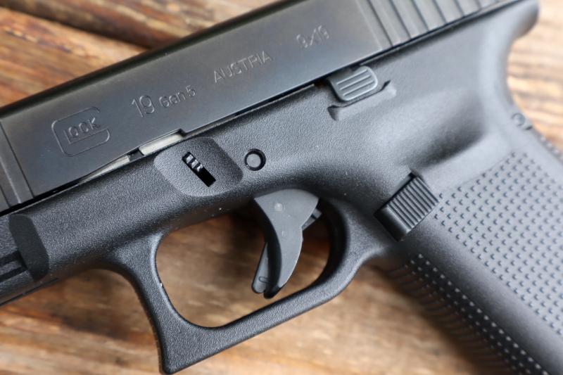 left side of a glock 19 Gen 5, laying on a wooden surface
