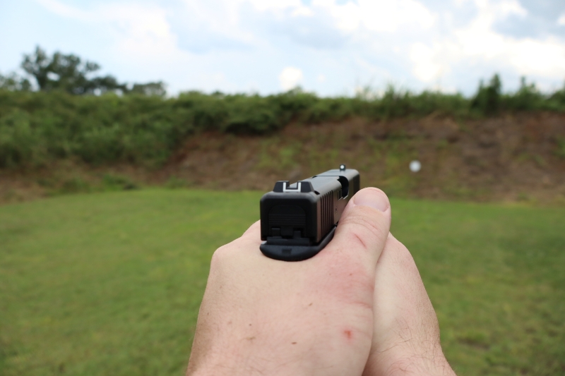 hands holding glock 19, looking downrange, with a clear view of the iron sights
