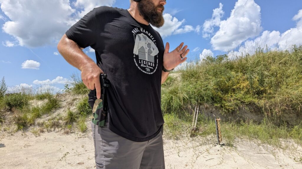 Man drawing black pistol, focused on the task.