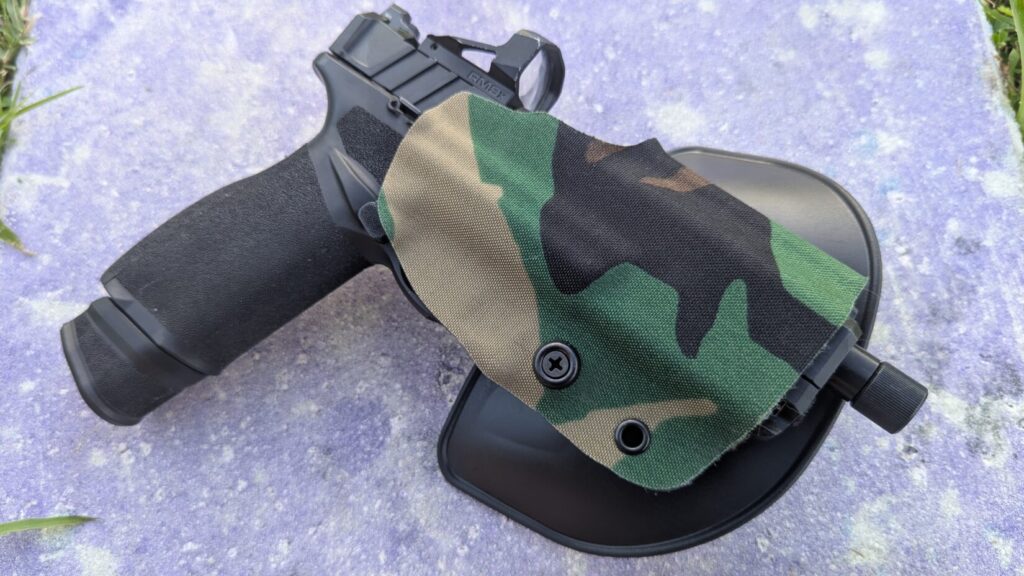 Black pistol and Gravity holster on concrete, close-up.