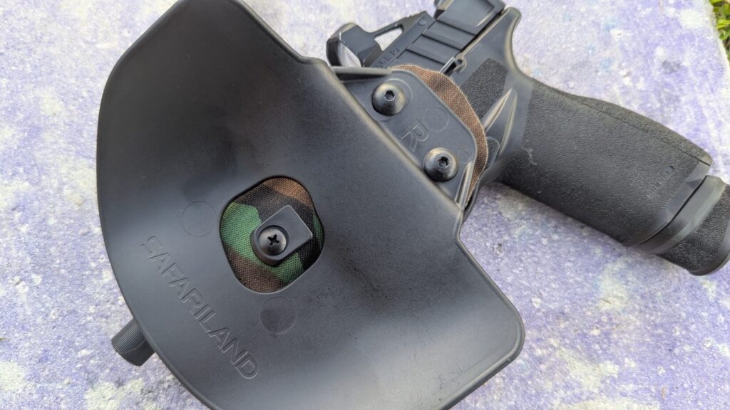 Black pistol and inside view of the paddle on Gravity holster on concrete.