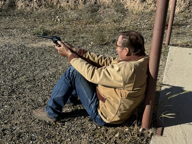 Handgun hunters need to practice from field positions. Gun Tales' Sheriff Jim Wilson is practicing from a steady seated position here.