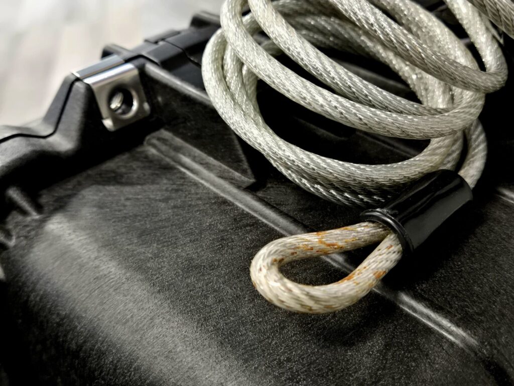 A coiled security cable on top of a pelican case