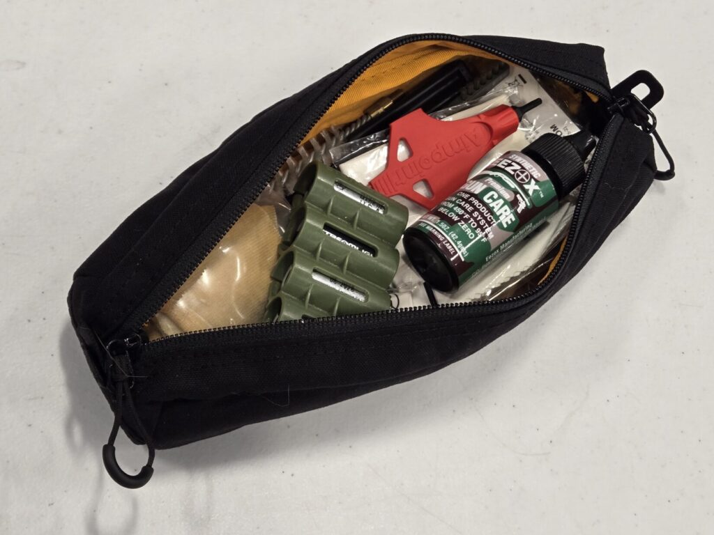Spare batteries, cleaning equipment, CLP protectant and other accessories inside of a small zippered case.
