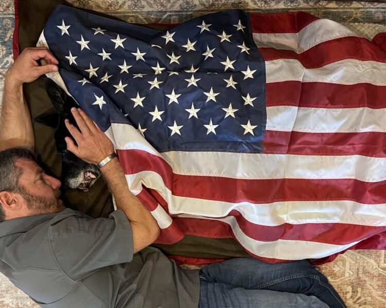 Pictured is Rick Hogg of War HOGG Tactical moments after his SOF K9 Duco lost his fight with cancer. Duco is covered by an American flag
