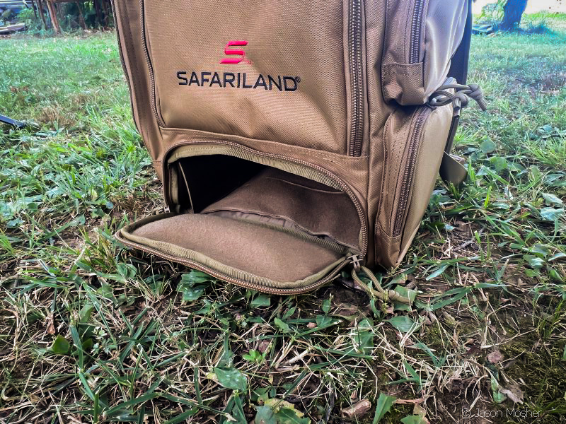 A brown backpack with the bottom compartment unzipped and open. This area is made to store ammo in.