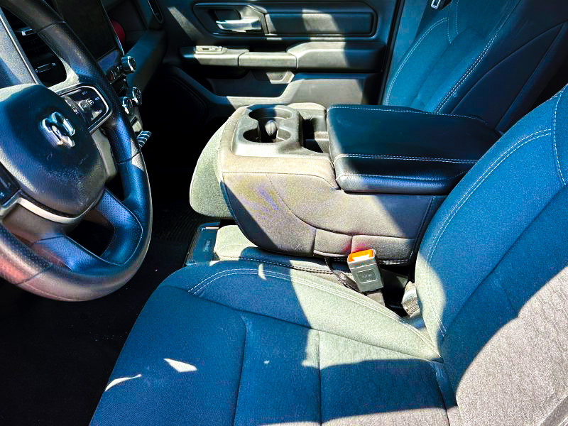 A view of the inside of the front cab of a truck from the driver's side door. 