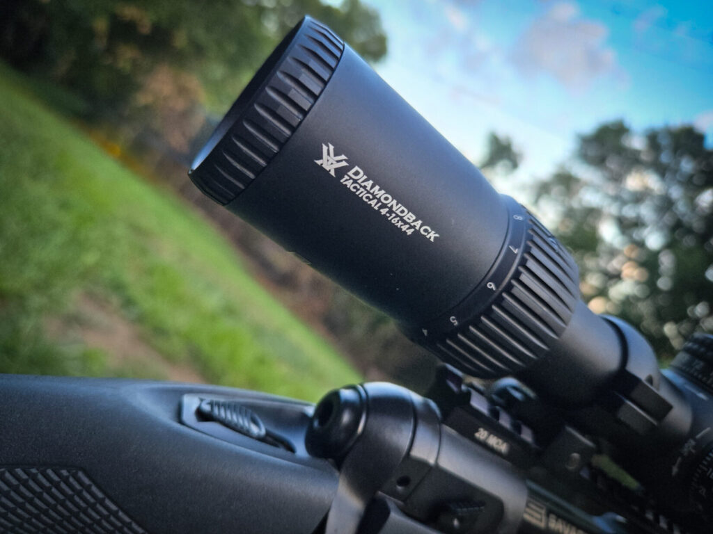 A close-up of a Vortex Diamondback Tactical rifle scope with white lettering