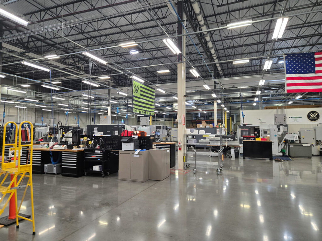 Vortex manufacturing facility with bright lights and multiple machines