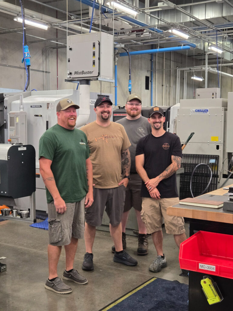 Vortex machine shop staff smiling under bright lights