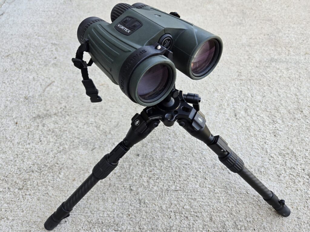 A pair of binoculars mounted to a miniature tripod from Spartan Precision Equipment