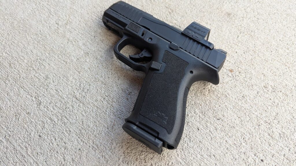 Close-up of the stippled grip and Palmetto State Armory logo on the frame of a PSA Micro Dagger pistol with a magazine inserted.