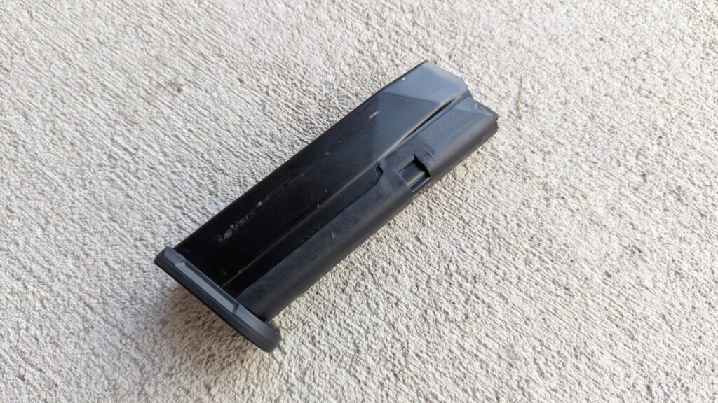 A pistol magazine for a PSA Micro Dagger rests on a concrete surface