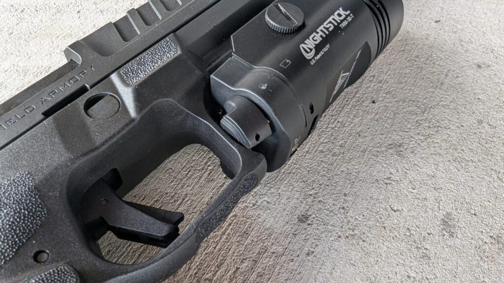 A close-up of the Nightstick TWM-30-T light mounted on the Echelon pistol, showing the light's controls.