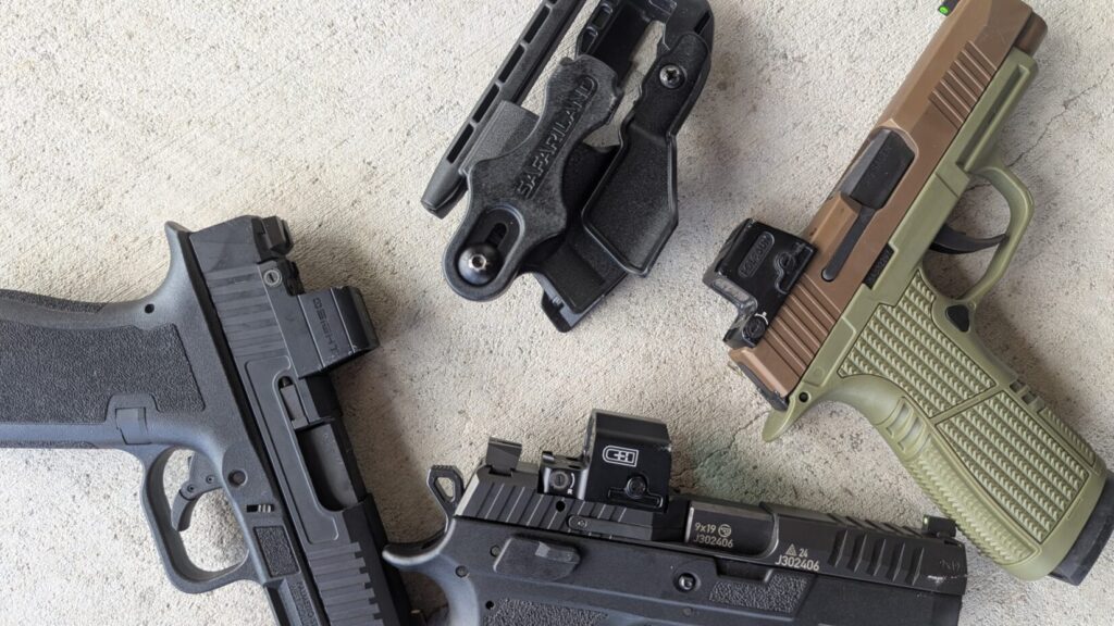 Three handguns and a black Safariland holster on a concrete surface. The handguns are a black one with an Osight S, a black one with an EDC Enclosed, and a two-toned tan and green one with a Holosun EPS Carry.