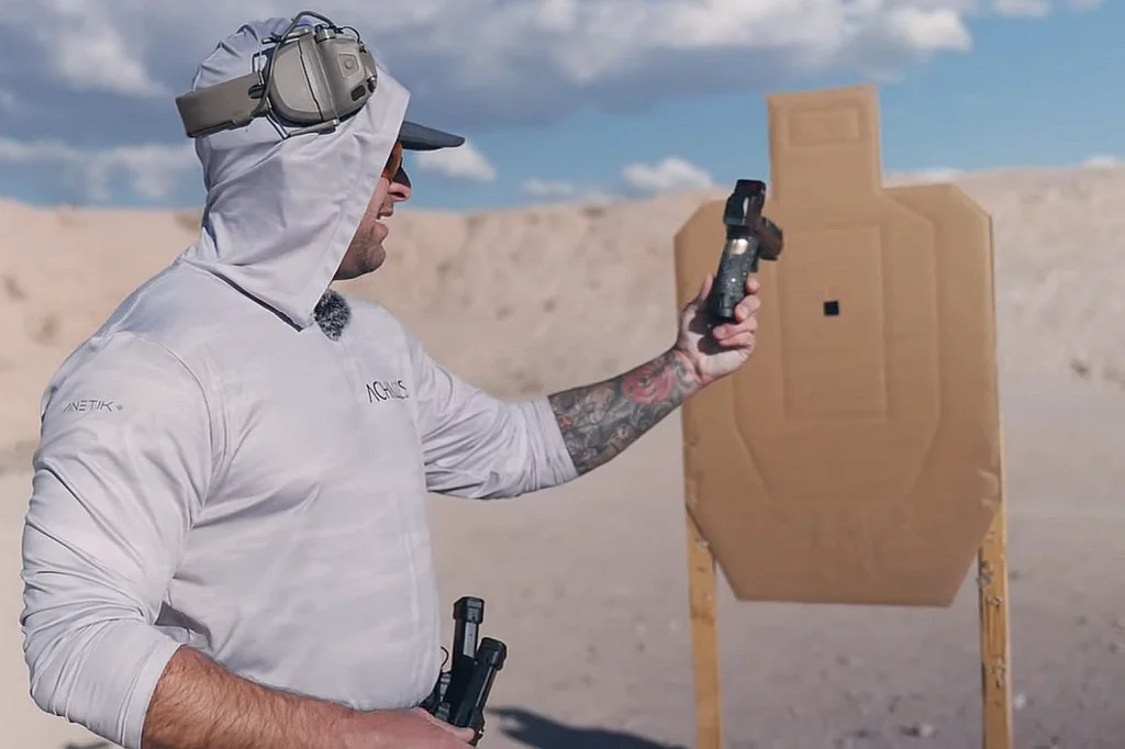 Man holding a semi-automatic pistol on a shooting range