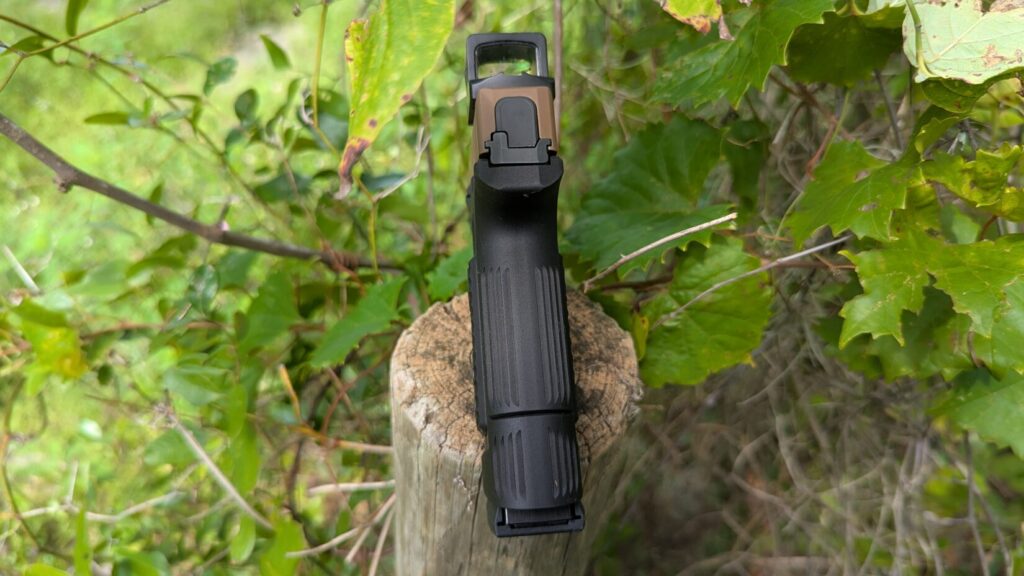 P365 with S365 grip and optic on a post, greenery behind.