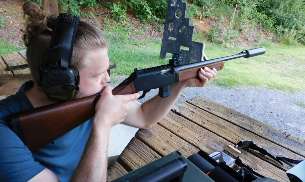 Man firing a suppressed Henry Homesteader carbine
