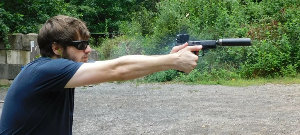 Man firing a suppressed semi-auto pistol