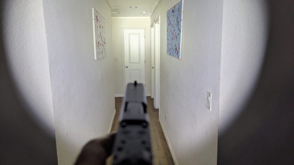 The Glock 17 with the Streamlight TLR-1 HL-X shining in indoor hallway