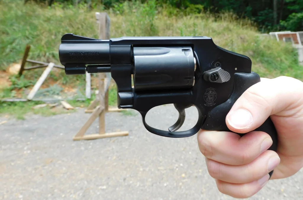 Smith & Wesson 442 revolver in hand at outdoor range