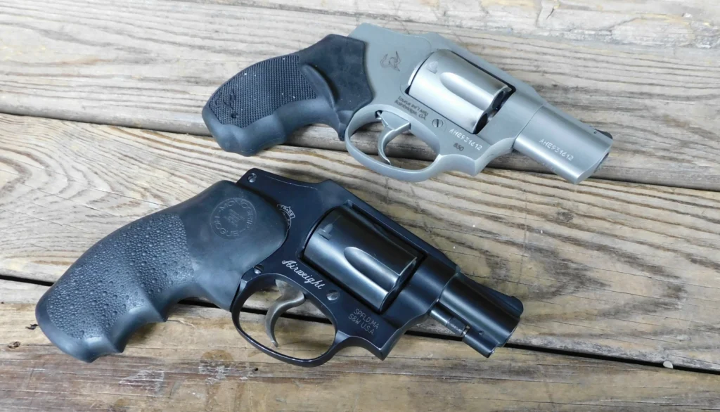 Two revolvers lying on a wooden table