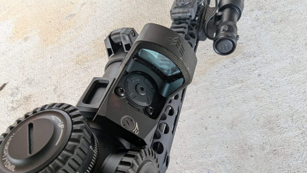 A close-up of the Swampfox Justice 2 red dot sight mounted on top of a Swampfox LPVO.