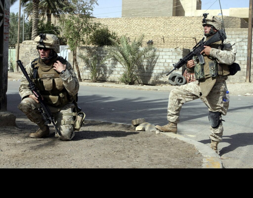 Two Marines from the 1st Battalion, 6th Marine Regiment in Fallujah, Iraq, during July 2005. (U.S. Marine Corps photo by Cpl. Mike Escobar, 2nd Marine Division. Public Domain)