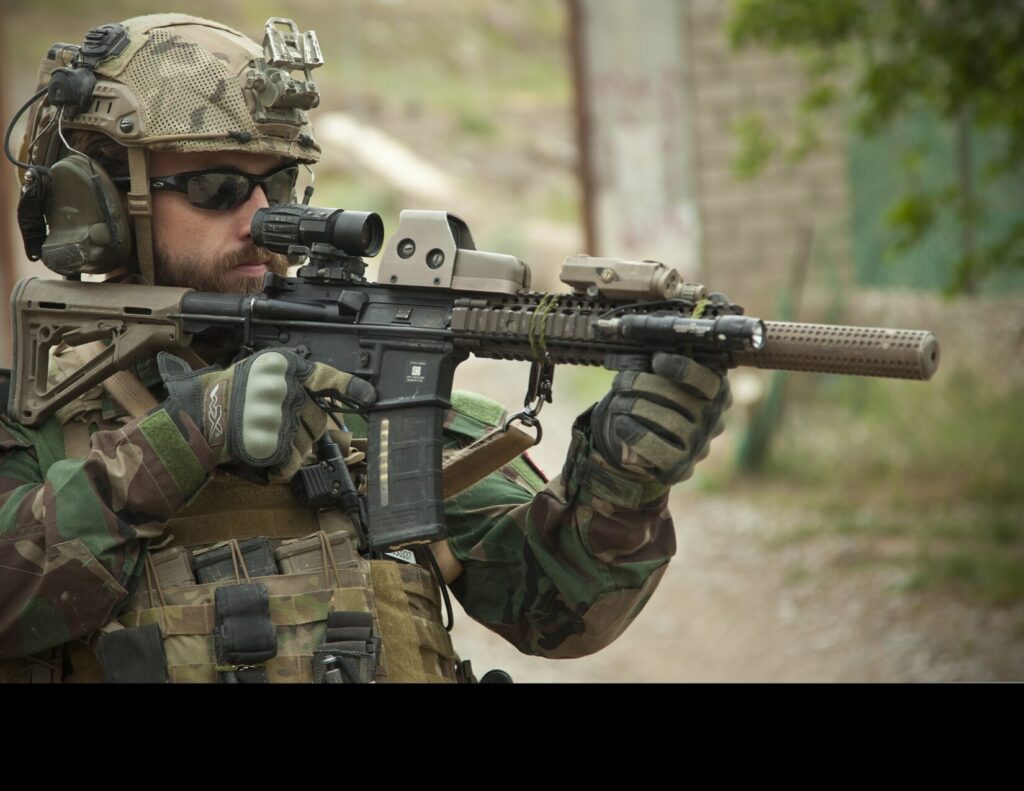 A U.S. Special Operations Marine provides security as Afghan Local Police members collect their first payments in Helmand province, Afghanistan, April 9, 2013. (US. Marine Corps photo by Sgt Pete Thibodeau. Public Domain).