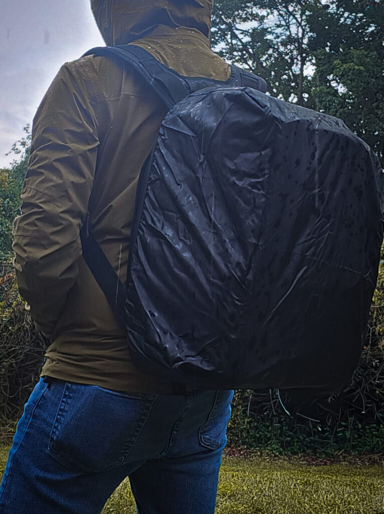 a black, rain-soaked backpack with a waterproof cover