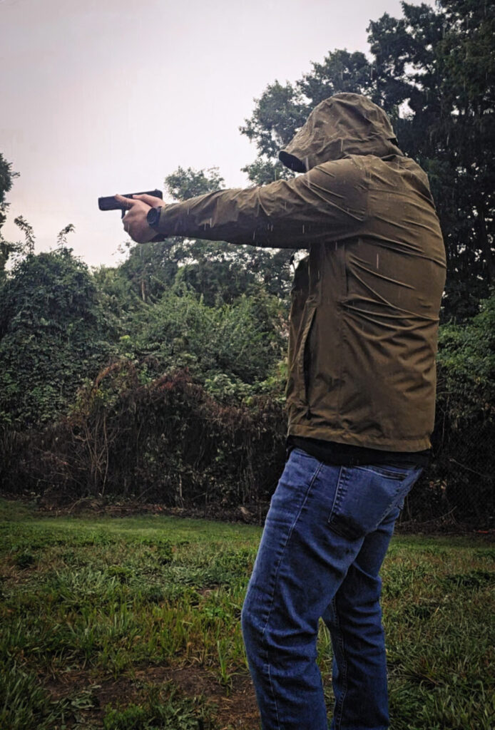 man shooting a Glock 17 in the rain