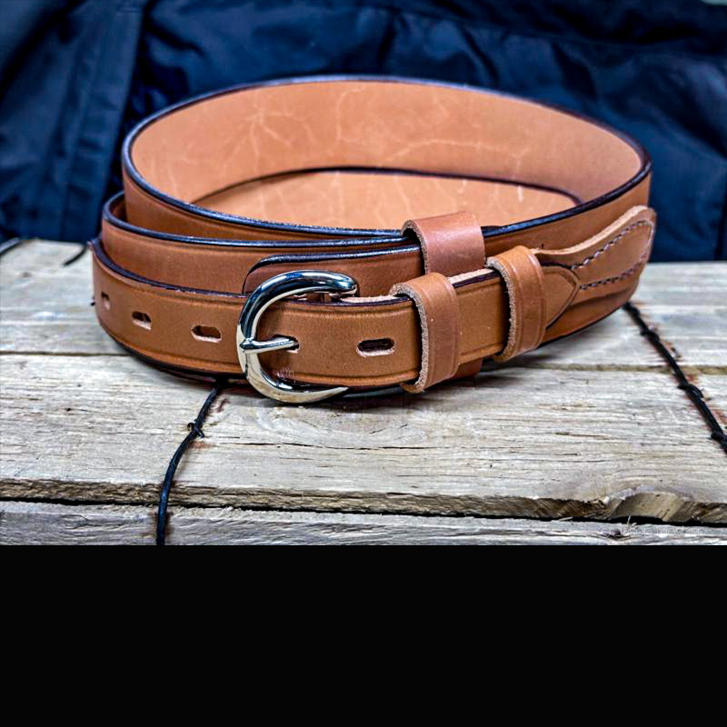 A Bianchi, brown leather gun belt, rolled up on a wood box. 