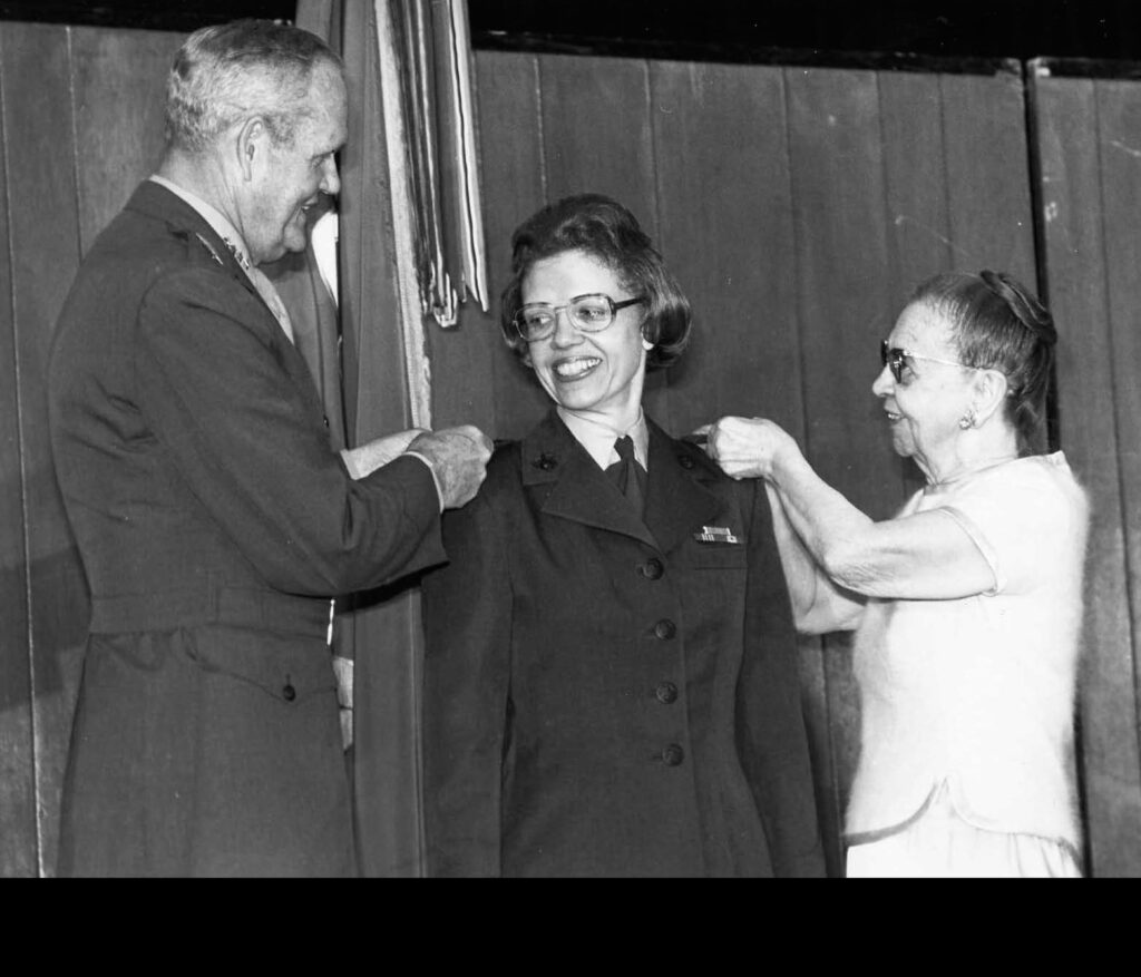 Gen. Louis H. Wilson, commandant of the Marine Corps, and Anne Brewer pin a star to each shoulder during the promotion ceremony for Brig. Gen. Margaret A. Brewer, May 11, 1978. She was the first female Marine to be promoted to brigadier general. (US. Marine Corps photo. Marine Corps History Division. Public Domain)