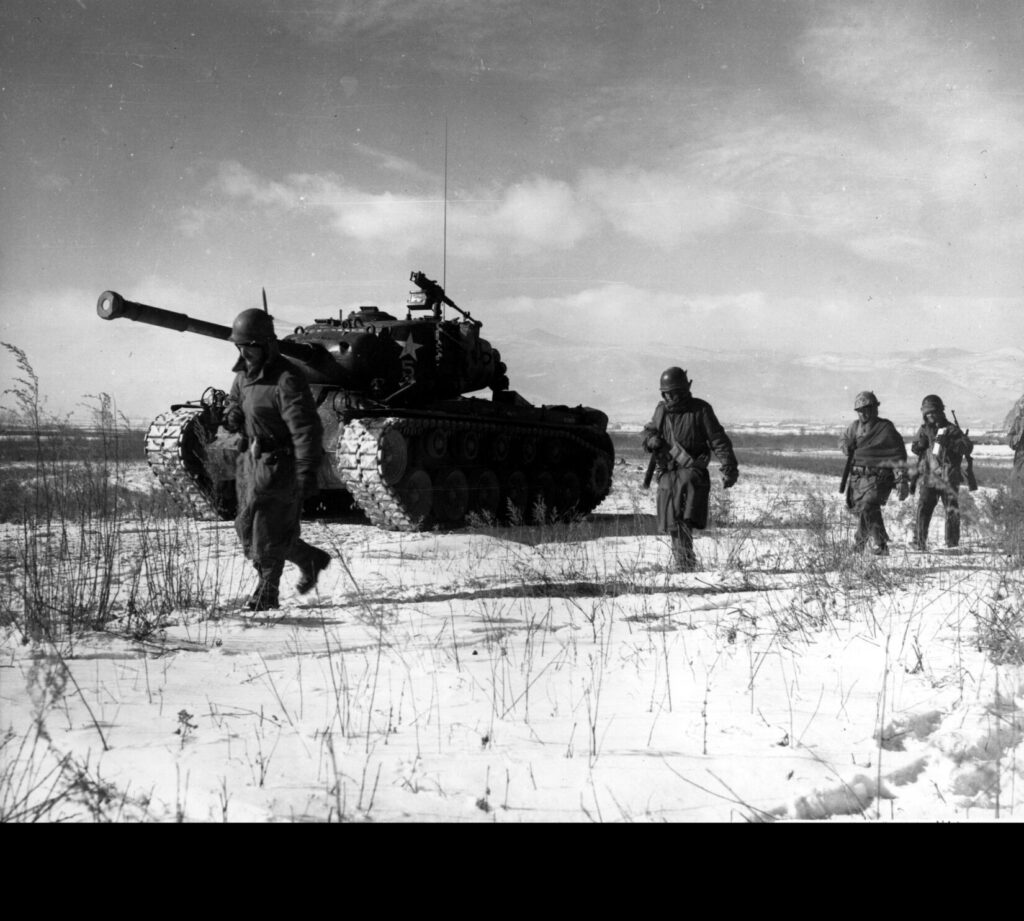 A column of the U.S. 1st Marine Division moves through Chinese lines during its breakout from the Chosin Reservoir with a M46 Patton medium tank. (U.S. Marine Corps photo. Public Domain)