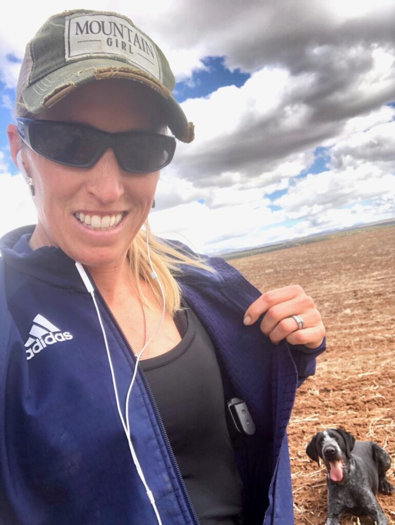 woman athlete showing handgun in shoulder holster under a hoodie