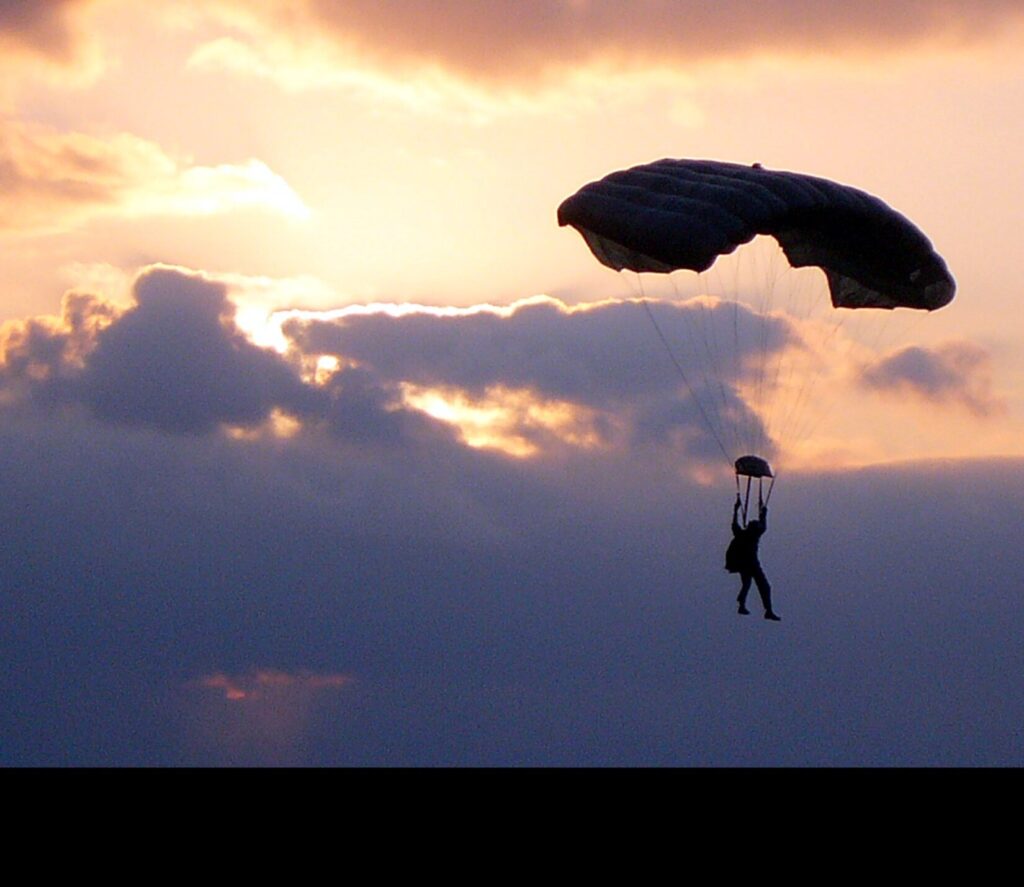 A Marine from G Company, 2nd Marine Special Operations Battalion, glides through the sunset sky towards his target during recent military freefall operations at Marine Corps Base Camp Lejuene. (US. Marine Corps photo by Gunnery Sergeant E.V. Walsh. Public Domain)