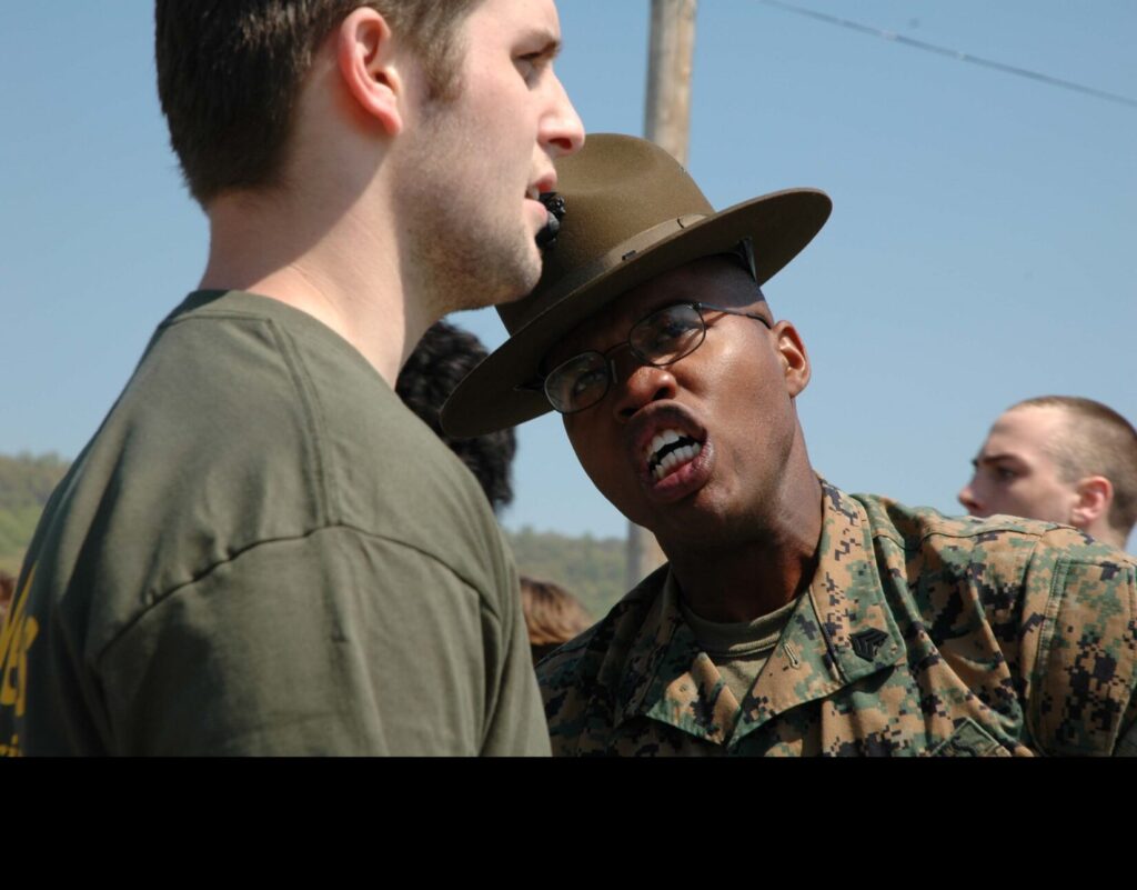 A drill instructor with 3rd Recruit Training Battalion, Marine Corps Recruit Depot Parris Island, South Carolina, gives a Delayed Entry Program poolee an example of the harassing instructional style to be expected at boot camp. (U.S. Marine Corps photo by Staff Sergeant J.L. Wright Jr. Public Domain)