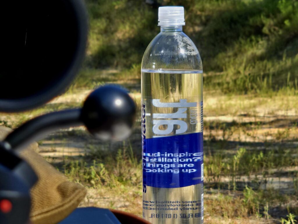A water bottle in focus and a rifle bolt in the foreground out of focus