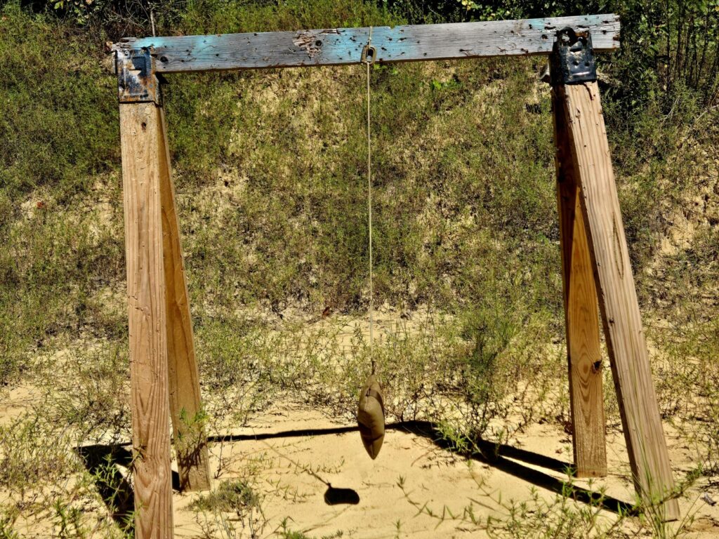A saw horse with a bag hanging from a string