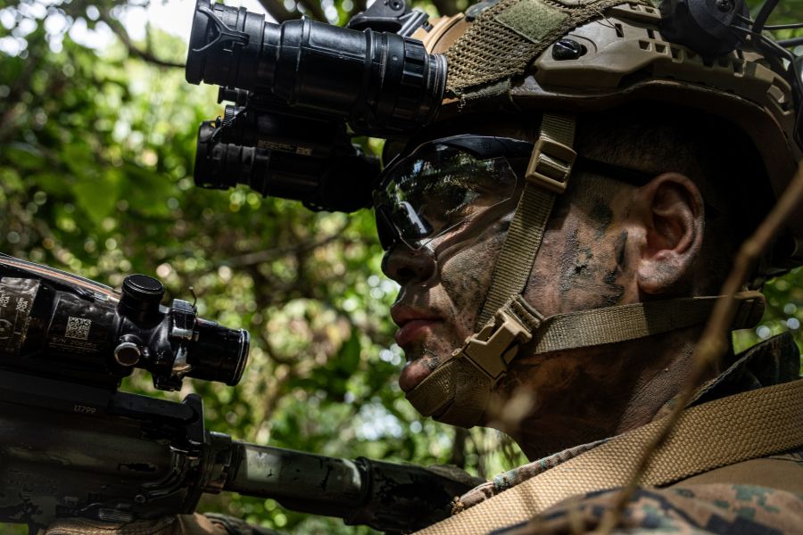 A US Marine looking forward while wearing a helmet and night vision goggles. 