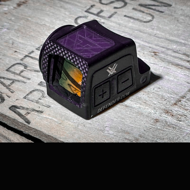 Vortex Defender CCW red dot on a wood box. 
