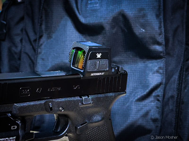 A Glock 47 with the Vortex Defender-ST enclosed red dot on display with a dark backkground. 