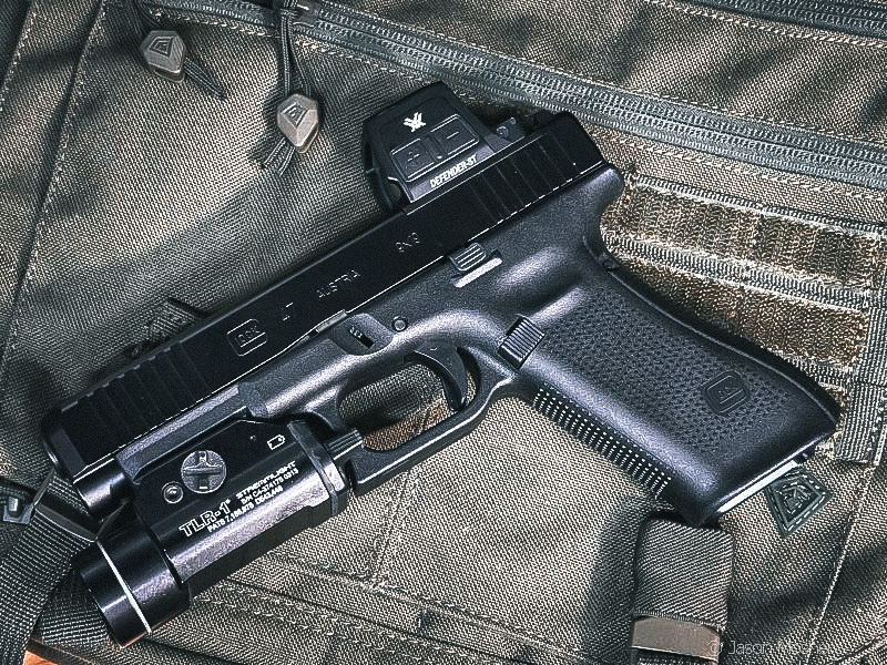 A black Glock 47 with a Defender-ST optic laying on a green bag. 