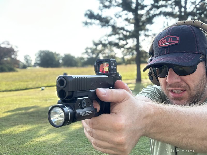 A person wearing a black hat and sunglasses, shooting a Glock 47 with the new Vortex Defender-ST enclosed optic mounted to it. 