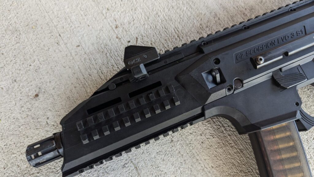 A close-up view of the front section of a CZ Scorpion Evo 3 pistol, showing the barrel, handguard, and rail.