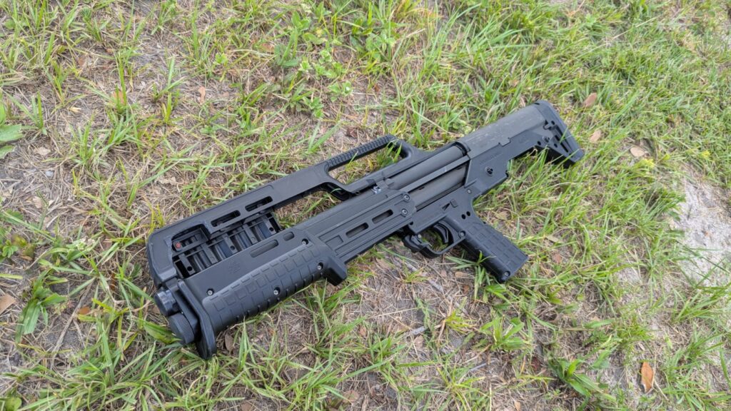 A top-down view of a black KelTec KS7 shotgun on a patch of green grass.