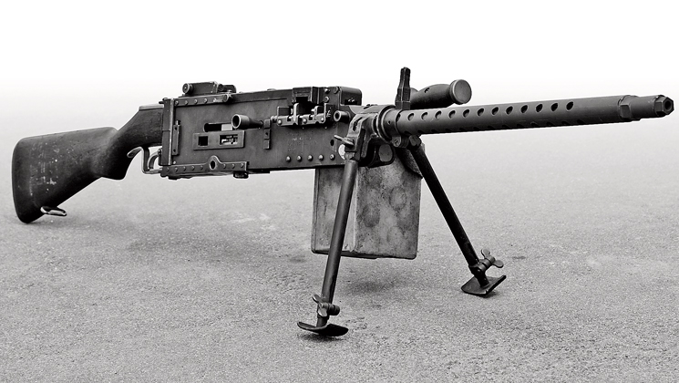 Black-and-white photo of a WWII M2 Stinger machine gun on a bipod, showing its long ribbed barrel