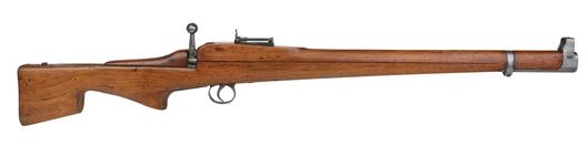 A classic, long wooden rifle with a bolt-action mechanism is shown against a white background. The bolt handle is visible on the right side of the receiver.
